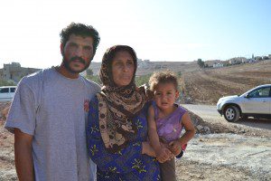 Abdel el-Razek, his wife, and their youngest child outside their tent near Irbid, Jordan.