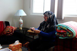 Fatoum Al Kurdi receives an MCC comforter at her family's new apartment in Winnipeg, Manitoba. MCC photo by Emily Loewen.