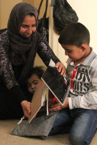  Asar and her sons Musab and Abdilbari open an MCC school kit they will use at an after-school educational program they attend in Jordan. The Syrian family has been in Jordan since 2014, but her husband can only find work a few days a month. Their last names are not used for their security. (Photo courtesy of Jane Ellen Grunau)  